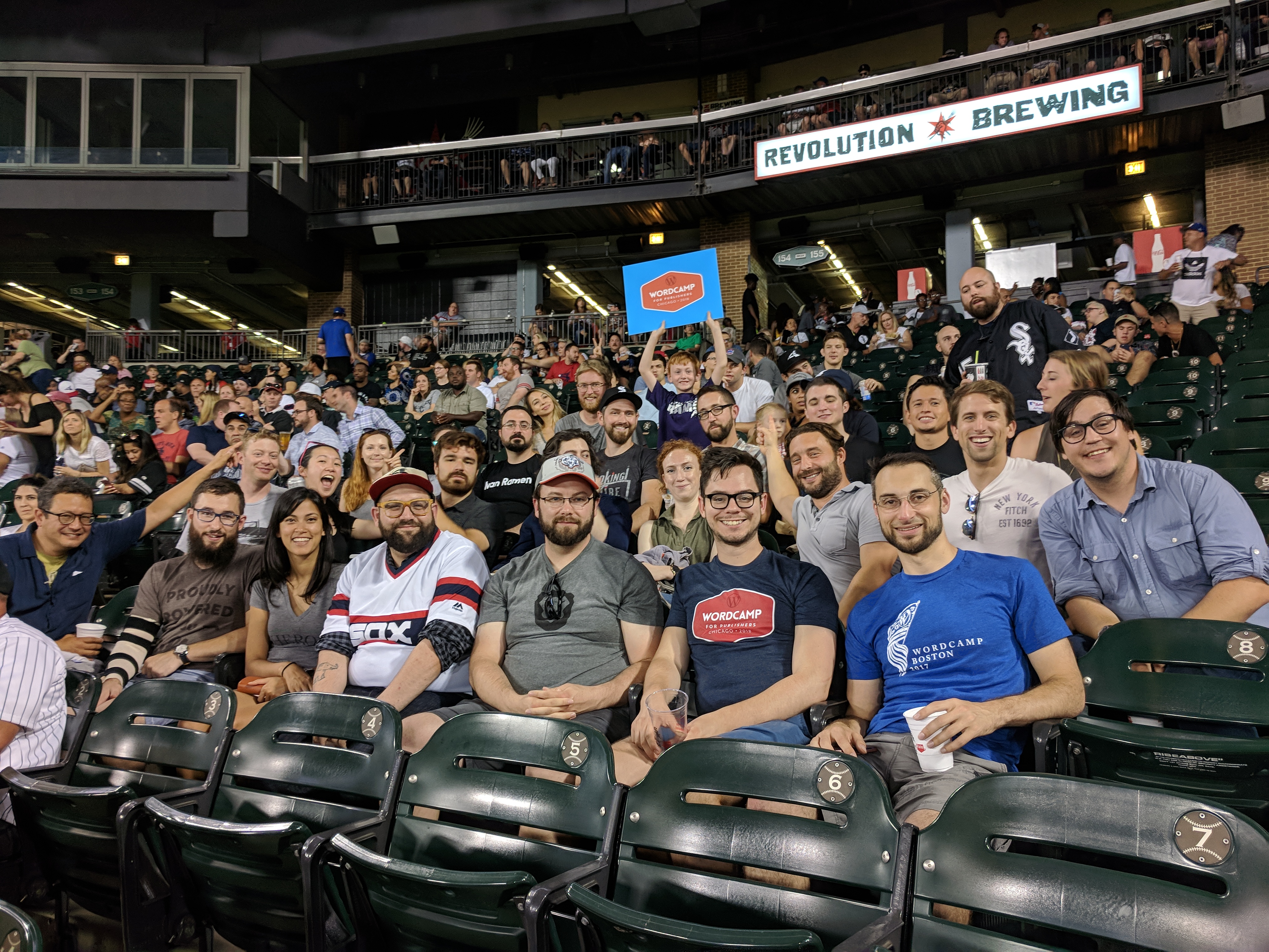 A group of people sitting in the stands of a baseball stadium