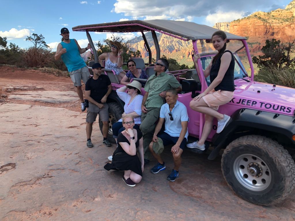 The team posing around their pink jeep after a tour of Sedona hiking trails.